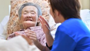 女性を介護する介護士